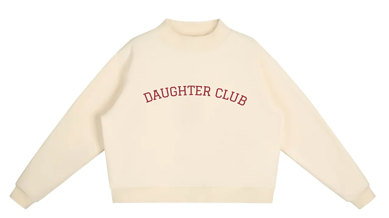 A cream sweatshirt with Daughter Club arched across the chest.