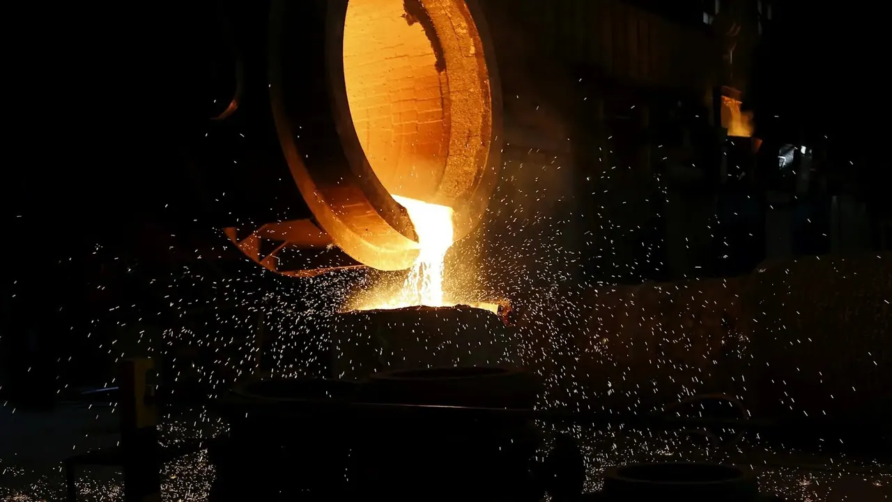 Molten metal pouring from a ladle in a shower of sparks.